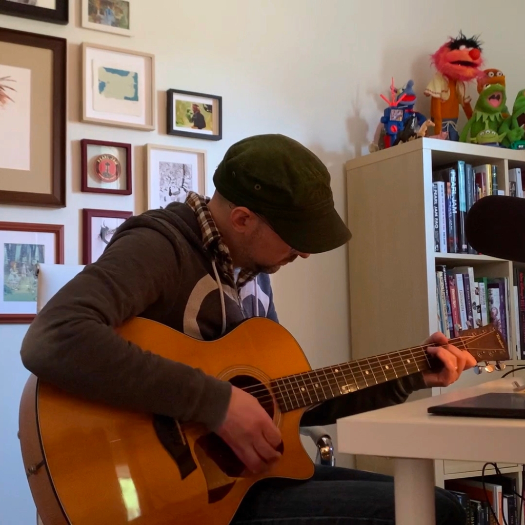 Chris Oatley practices the guitar chords to A Long December by The Counting Crows 
